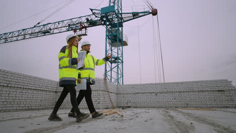 building-inspection-in-construction-site-two-civil-engineers-are-walking-in-under-construction-building