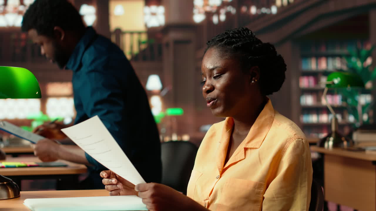 Female scholar engrossed in her studies at a university library desk