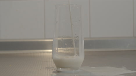 milk being spilled on kitchen counter while filling glass