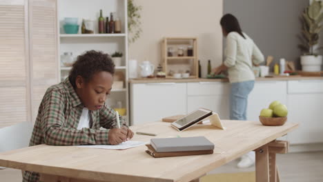 mother helping child with homework in kitchen