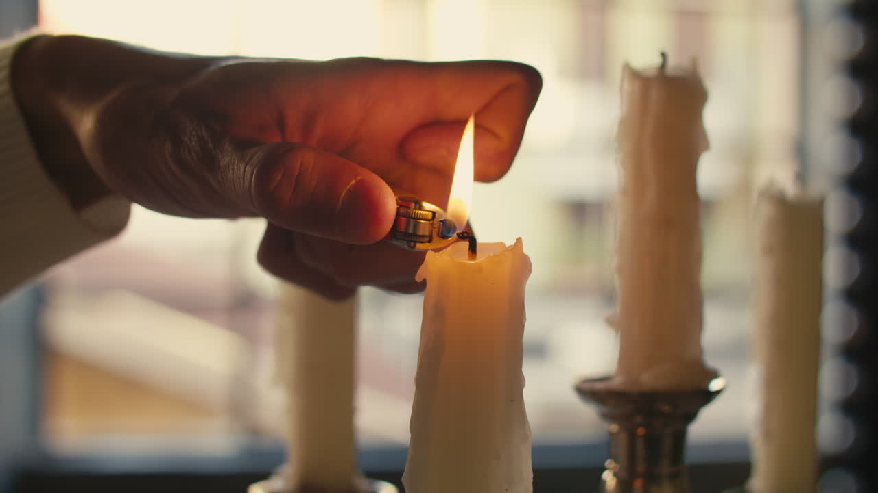 Mano maschile che accende una candela con un accendino