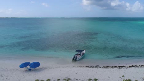 romantic sunset caribbean island with boat and two beach chairs