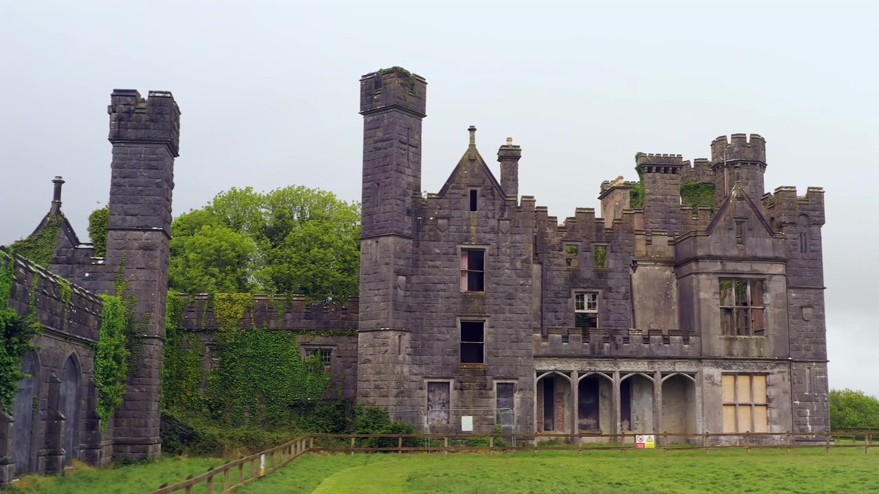 Inquadratura di presentazione a scorrimento laterale della facciata posteriore del Castello Saunderson che rivela un'architettura ornata e giardini