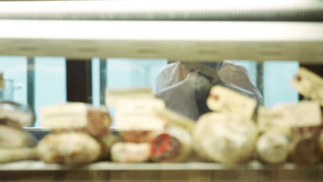 butchers at work seen through cold storage of meat products