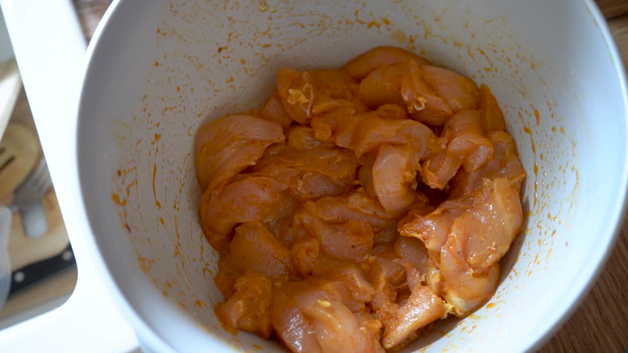 un plato de pechuga de pollo cruda en adobo