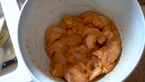 un plato de pechuga de pollo cruda en adobo