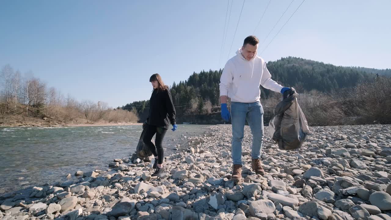 команда очищает пластик на пляже. добровольцы собирают мусор в мусорный мешок. загрязнение пластиком и концепция экологической проблемы. доброволная очистка природы от пластика. озеленение планеты