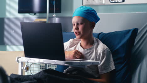 child patient using laptop in hospital bed