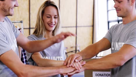 voluntarios sonrientes con las manos apiladas