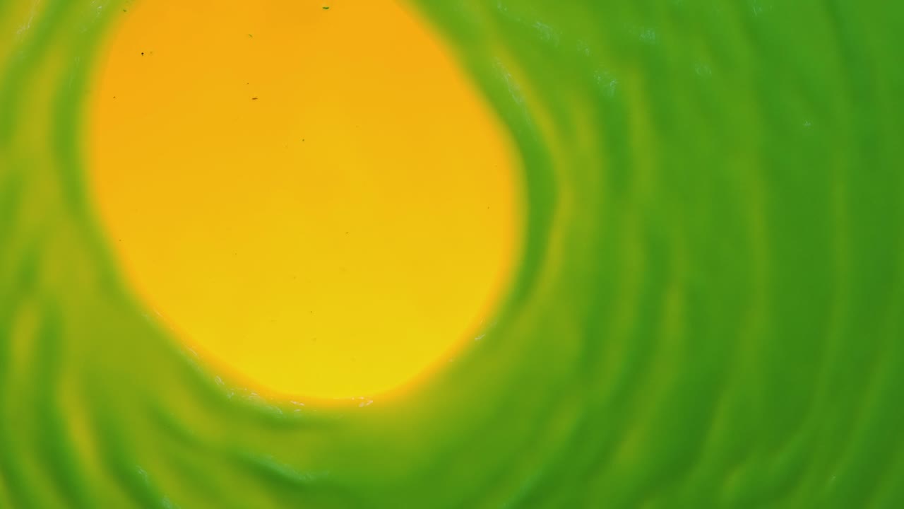 el viento sopla en el centro de la pintura fluorescente y la sopla en forma de círculo. vista superior. fondo abstracto de color.