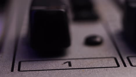 channel 1 on mixing console, moving fader up and increasing sound volume, macro close up