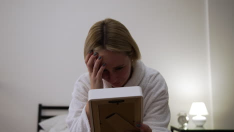 sad man holding picture with frame