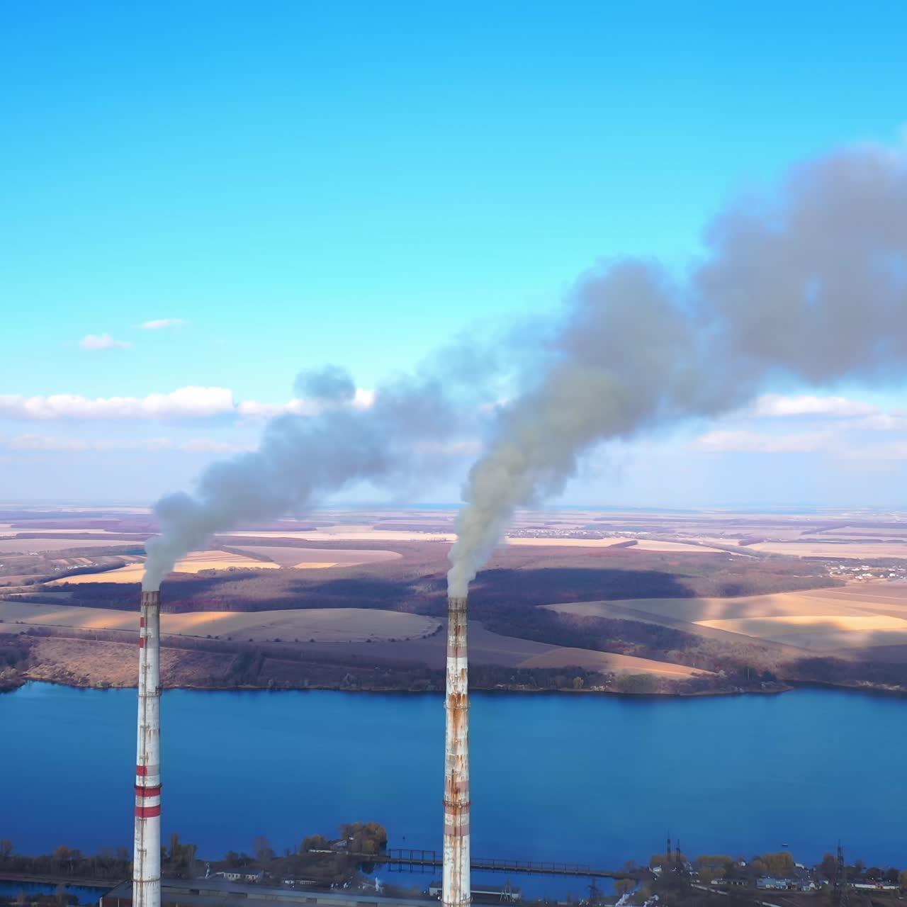 Aerial view of smoking factory tubes. Indusrty energy producing air pollution