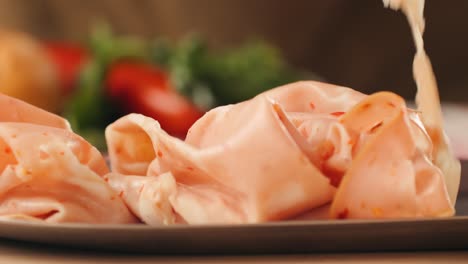 ham italian mordatella, man slices of traditional italian antipasti mortadella sausage on a wooden cutting board, close up macro of chicken or turkey jamon, fat breakfast dish.