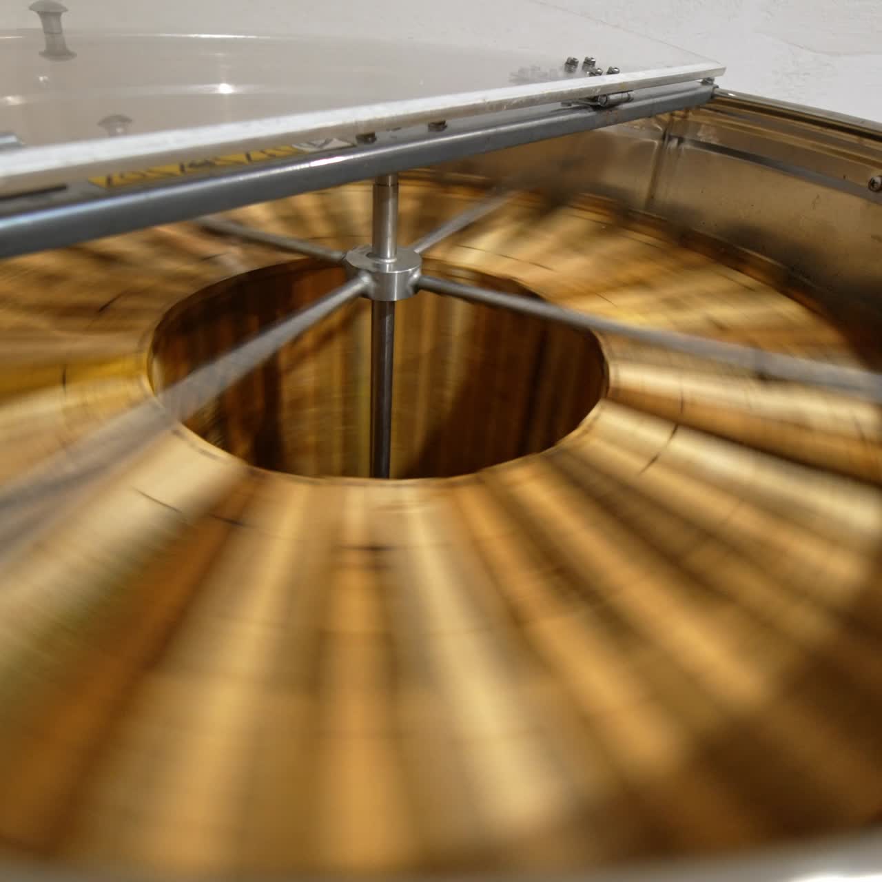 Macchina per la rimozione del miele che ruota i telaini con miele biologico. Raccolta di un prodotto sano in un allevamento di api rurale. Primo piano