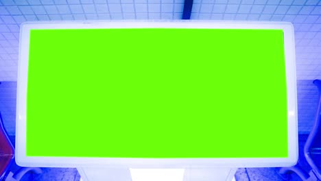 big green screen billboard on airport wall. widescreen chroma key mock up subway frame for advertisement.