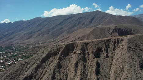 Wide-forward-aerial-of-Cerro-de-la-Cruz-cross-and-mountains,-Argentina