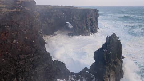 el mar salvaje chocando en los altos acantilados de islandia en un día tormentoso