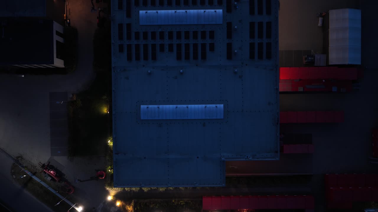 Aerial view of Warsaw warehouses at night with solar panels and lights