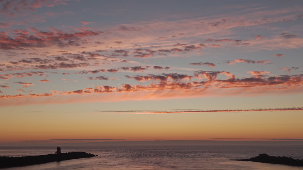 Drone flight towards ocean at Bandon Oregon jetty. Seagulls flying by. Serene Oregon Coast seascape at sunset
