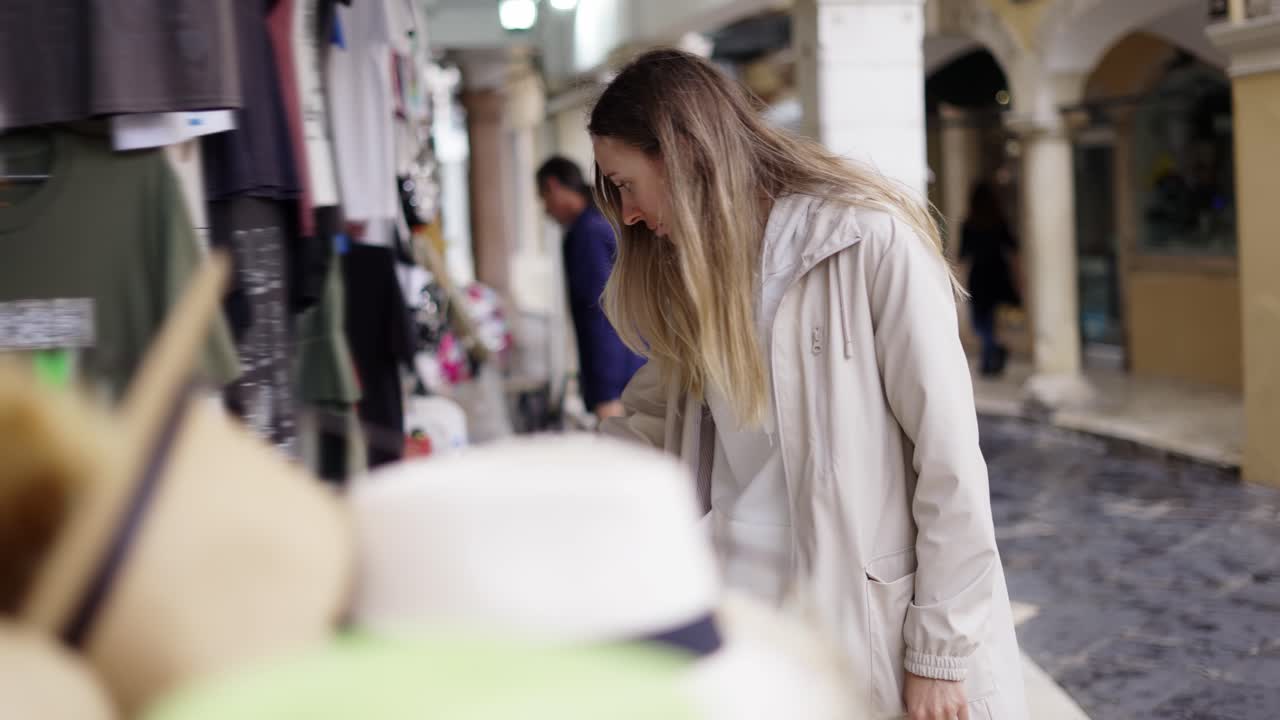 mujer turista de compras en el bazar de la calle de la ciudad, buscando una pequeña estatuilla