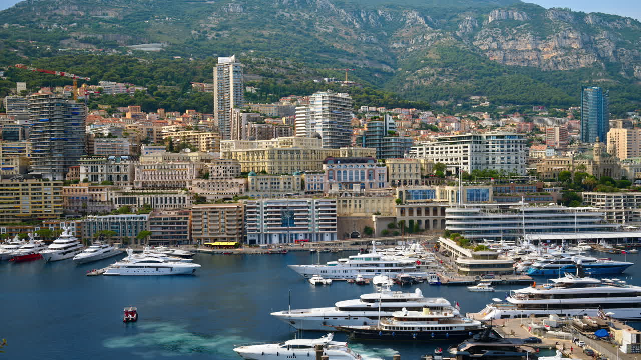 View of boats docked in the Monaco Marina with the skyline of the city on the background