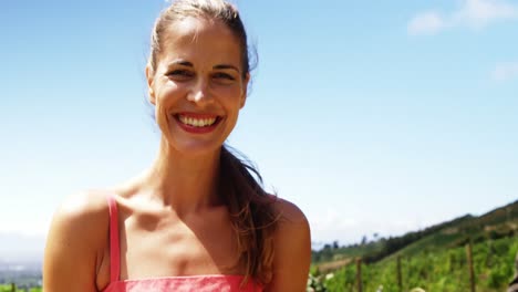 portrait of happy young woman using mobile phone in field