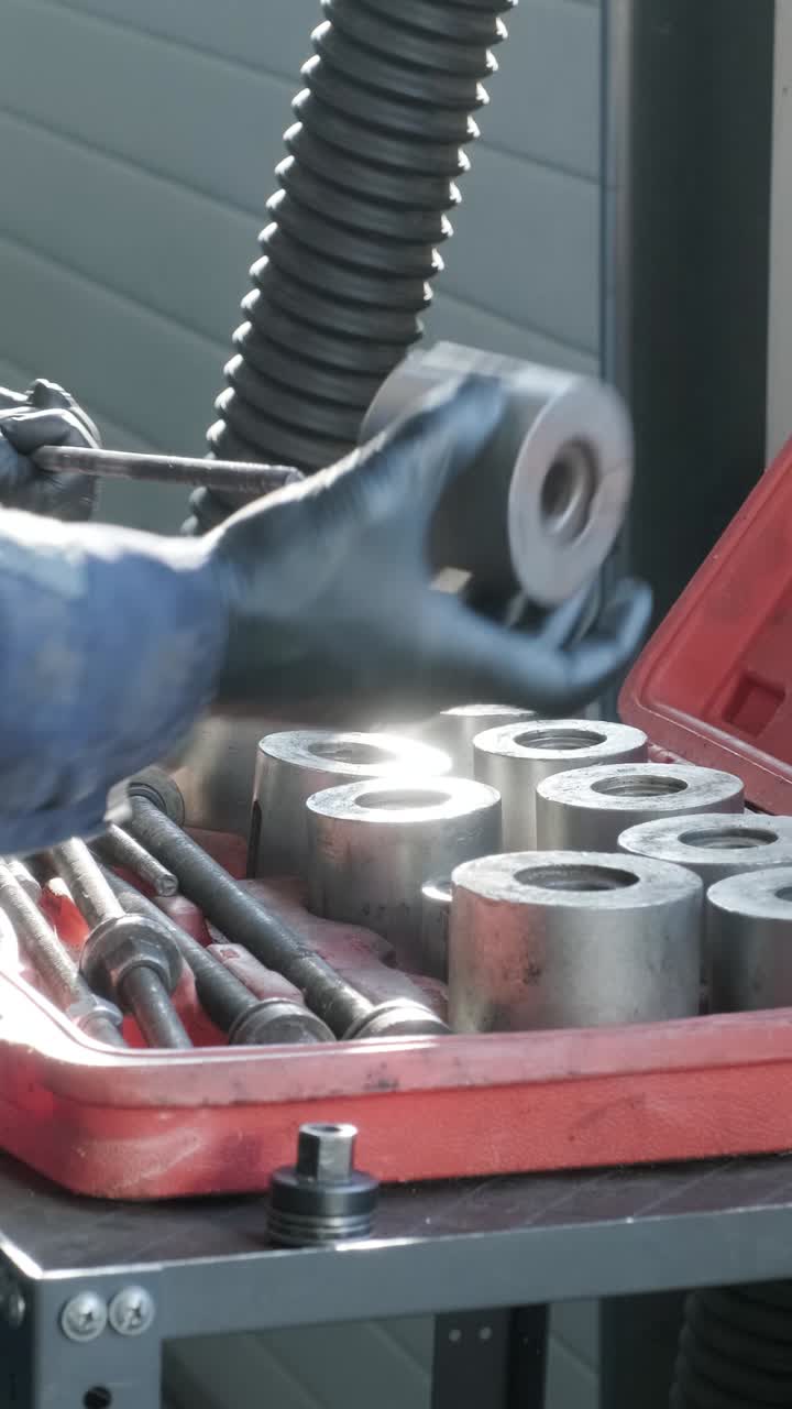 Mechanic's Hands in Gloves Selecting Metal Tools from a Toolbox