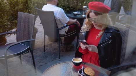 coffee break with croissant. modern urban young woman working online on cell phone on cozy restaurant terrace