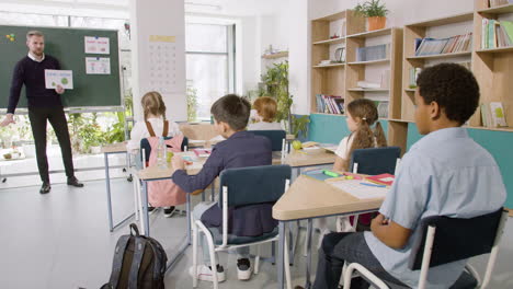 Profesor-Enseña-A-Un-Grupo-De-Estudiantes-Multiétnicos-Las-Palabras-&#39;bajo&#39;-Y-&#39;alto&#39;-En-El-Aula-De-Inglés