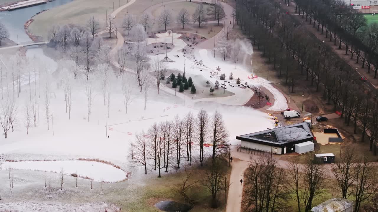 Snowmakers in action on foggy day in Riga’s park, symbol of warming winters