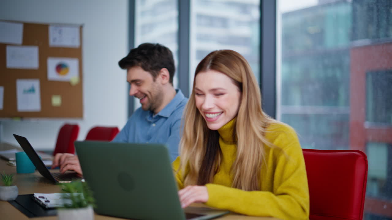 Happy colleagues analyzing startup sitting workplace closeup. Smiling woman man
