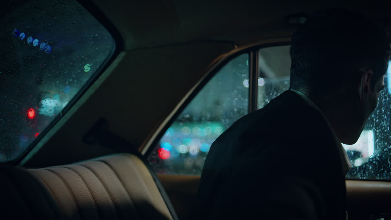 Focused passenger riding rainy window car closeup. Business man correcting suit