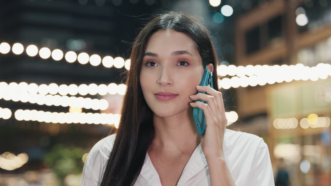una mujer hablando por teléfono por la noche.