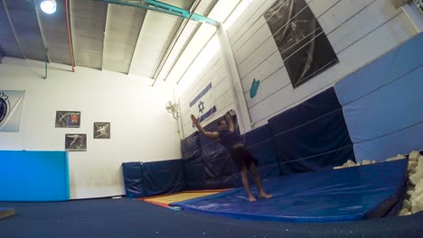 a-slow-motion-still-shot-of-a-guy-doing-flips-from-the-trampoline-landing-and-winning-having-fun-and-working-out-in-60fps