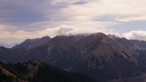 white clouds float in sky gathering on top of mountain ridgeline in agrafa greece