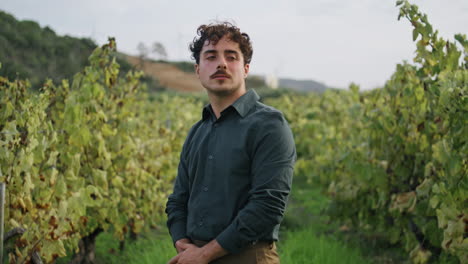 farmer standing grape plantation with yellow grapevine close up. worker posing.