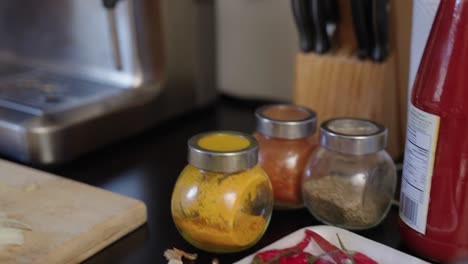 pieles de cebolla, chiles, especias y manos de mujer marrón cortando cebollas