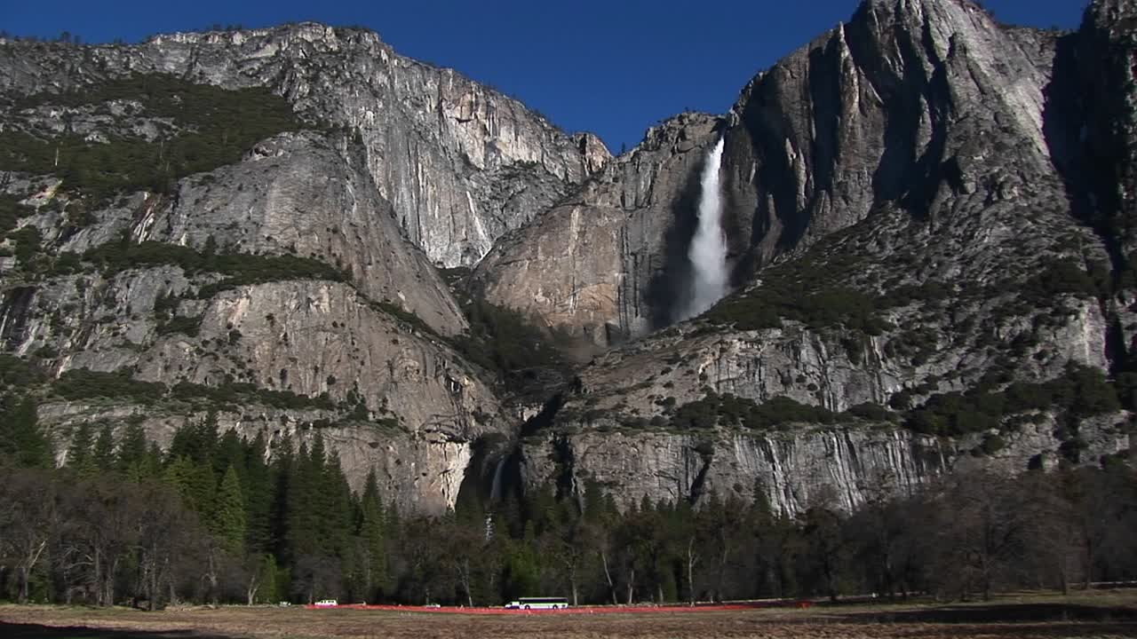скалистые горы - водопад и движение у основания гор