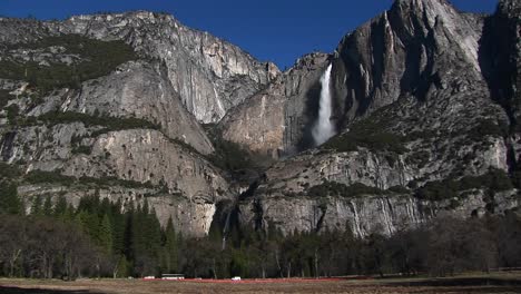 rocky mountains feature a waterfall and traffic at the base of the mountains