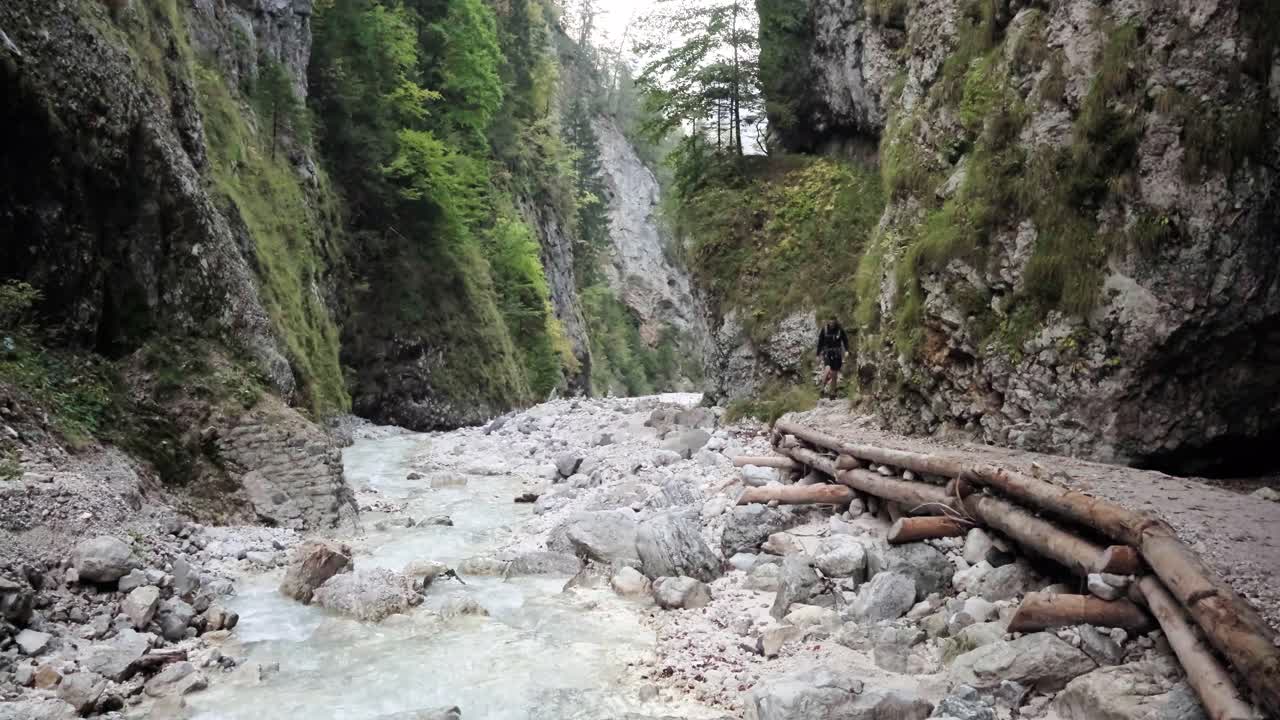 un hombre explorando la cascada martuljek durante el día en gozd martljek en eslovenia y el parque nacional triglav