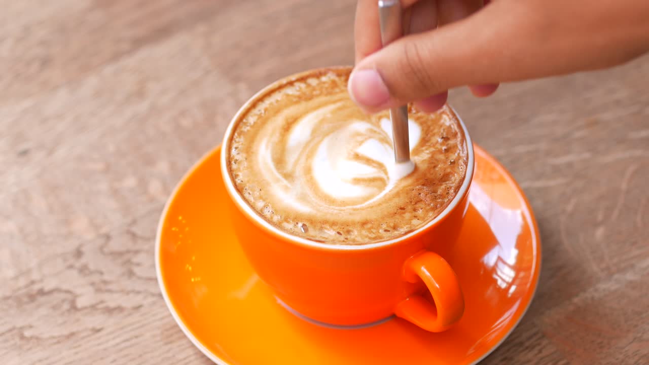 Closeup of a cup of latte with a heart design in the foam