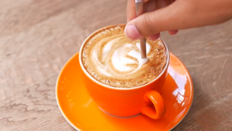 closeup of a cup of latte with a heart design in the foam