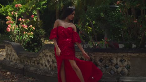 en medio de las salas cargadas de historia de un castillo caribeño, una joven adorna la escena en su elegante vestido rojo