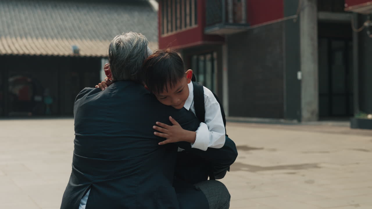 A Grandfather Greets His Grandson With A Hug