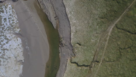 toma aérea de arriba hacia abajo, de las trincheras arenosas en la costa durante la marea baja