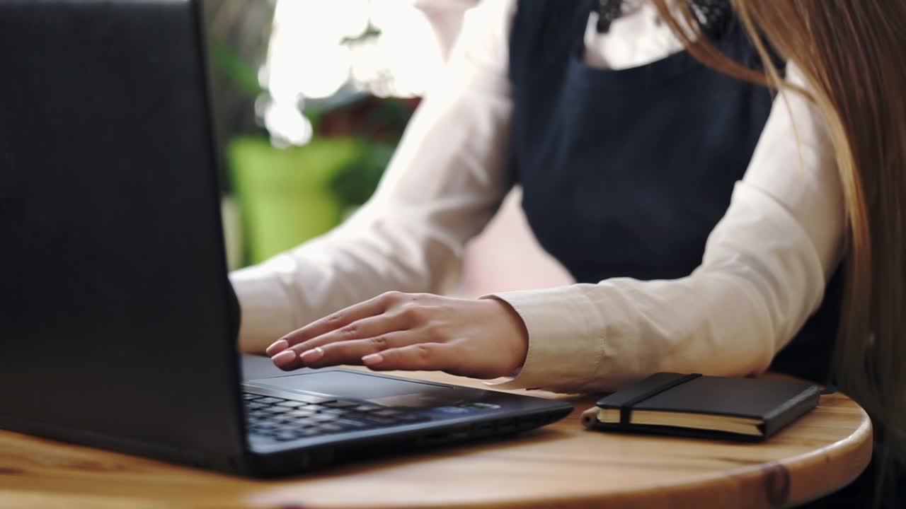 Donna che lavora al portatile in un caffè