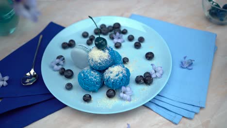 Präsentiert-Eine-Wunderschön-Arrangierte-Tischdekoration-Mit-Einer-Herrlichen-Blauen-Eisschale,-Dekoriert-Mit-Frischen-Blaubeeren