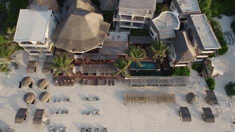 drone view of a sandy beach at sunset at amansala hotel resort in the village of tulum