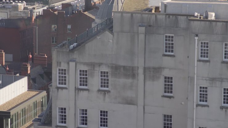 Panoramica verso il basso da vista a volo d'uccello, edificio nel centro di Manchester, uccelli in volo dal secondo 5, slow-motion 4K